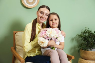 Anne ve kızı evde bir buket güzel şakayıkla