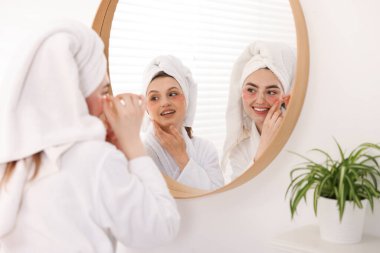 Bornozlu mutlu kadınlar aynanın yanında kaplıca ameliyatından sonra göz bandı takıyorlar.