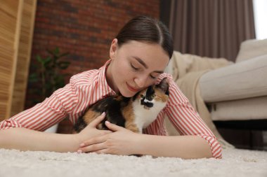 Şirin yavru kedisi evde yerde yatan bir kadın.