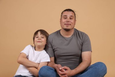 Babası ve oğlu bej arka planda.