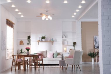 Odada rahat bir kanepe ve sandalyeli şık bir yemek masası. İç tasarım