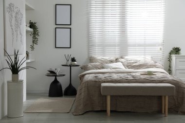 Yatak odasında güzel çarşafları olan rahat bir yatak.