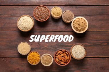 Tahta masadaki kaselerdeki farklı süper yiyecekler.