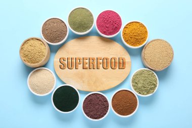 Süper yemek. Kâselerdeki farklı tozlar ve açık mavi arka plandaki pano düz.