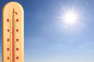 Güneşli bir günde mavi gökyüzüne karşı termometrede son derece yüksek sıcaklık. Yaz havası