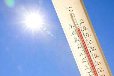 Güneşli bir günde mavi gökyüzüne karşı termometrede son derece yüksek sıcaklık. Yaz havası
