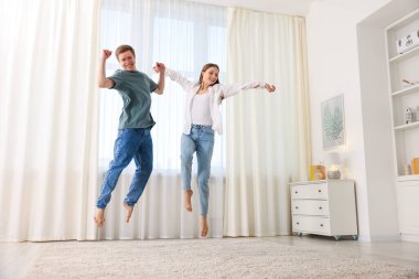 Mutlu genç çift evde dans ediyor, düşük açılı.