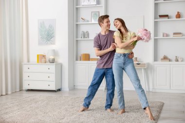 Mutlu genç çift evde dans ediyor.