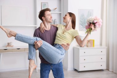 Mutlu genç çift evde dans ediyor.