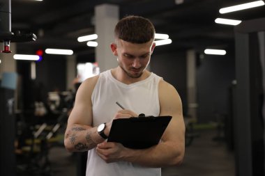 Spor merkezinde panosu olan kişisel antrenör.