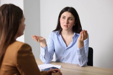 Genç bir kadın iş kadınına şikayet ediyor.