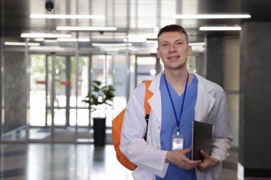 Sırt çantası ve dizüstü bilgisayarı olan tıp öğrencisi içeride, mesaj için yer var.