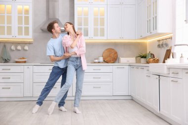 Mutfakta dans eden mutlu genç çift.