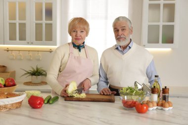 Son sınıf çifti mutfakta birlikte yemek pişiriyor.