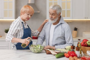 Son sınıf çifti mutfakta birlikte yemek pişiriyor.