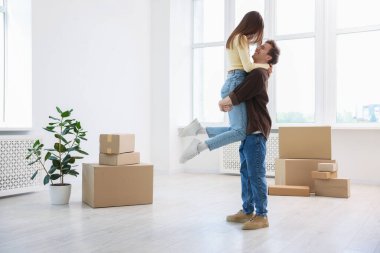 Evde dans eden mutlu genç çift ve karton kutular. Taşınma günü