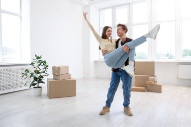 Evde dans eden mutlu genç çift ve karton kutular. Taşınma günü