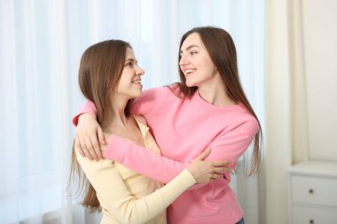 Mutlu arkadaşlar evde birbirlerine sarılıyorlar.