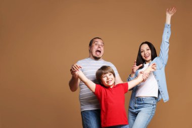 Kahverengi arka planda mutlu aile portresi