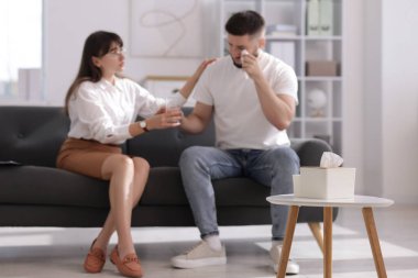 Ofisteki koltukta terapi seansında hastayı destekleyen psikolog, seçici odaklanma