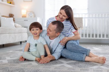 Sevimli küçük çocuk ve ailesi evde. Güzel aile.