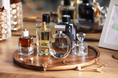 Farklı parfüm şişeleri ve aksesuarlar ahşap masada, yakın plan.