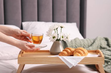 Kadın yatakta nefis bir kahvaltı yapıyor, yakın plan.