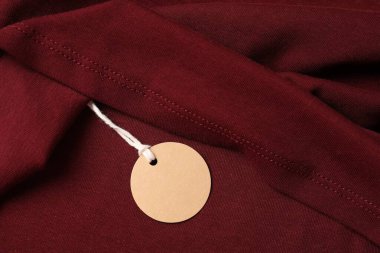 Kırmızı giysinin üzerindeki karton etiket, üst görünüm