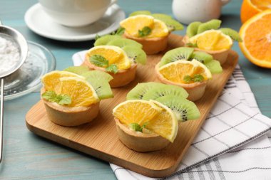 Meyveli tart ve açık mavi ahşap masada nane şekeri, yakın plan. Tatlı nefis.