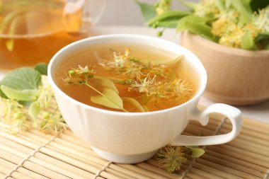 Taze ıhlamur çayı, çaydanlık ve çiçekler masada, yakın plan.