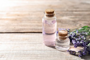 Doğal yağ ve lavanta çiçekleri ahşap masada, yakın plan. Metin için boşluk