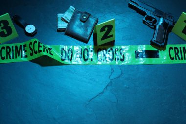 Adli tıp uzmanlığı. Deliller, işaretler, mavi arka planda polis bandı olan bir suç mahalli. Düz konum ve mesaj için yer. Renkli tonlama efekti