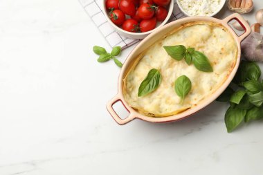 Lezzetli vejetaryen lazanya ve beyaz mermer masa üzerindeki malzemeler. Metin için boşluk