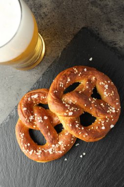 Lezzetli krakerler ve koyu dokulu masada bir bardak bira.