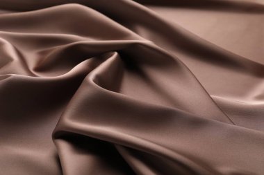Arkaplan olarak buruşuk açık kahverengi ipek kumaş, yakın plan
