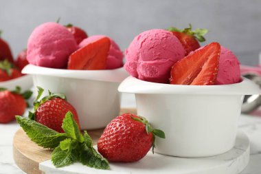 Tazeleyici şerbet, çilek ve nane şekeri beyaz mermer masada gri arka planda, yakın plan