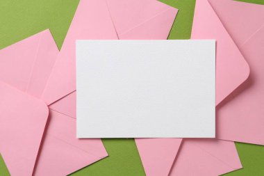 Boş davetiye kartı ve yeşil arka planda zarflar. Tasarım için boşluk