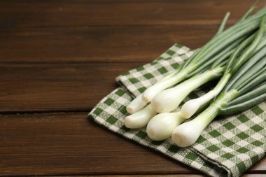 Taze taze taze soğan ve ahşap masada havlu, yakın plan. Metin için boşluk