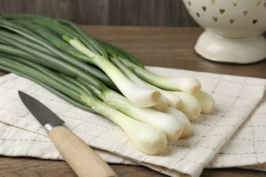 Taze taze soğan ve bıçak ahşap masada, yakın plan.