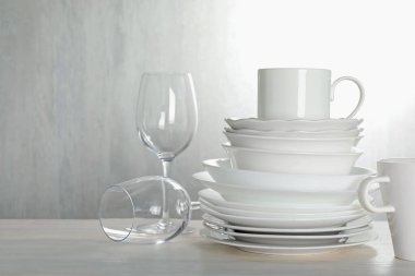 İçerideki açık ahşap masada farklı temiz bulaşık takımı.