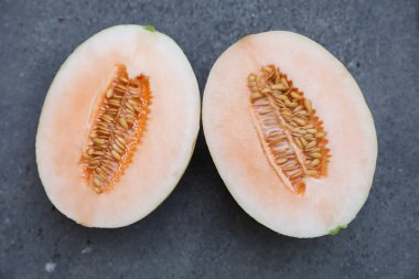 Gri arka planda sulu kavun yarıları, üst görünüm