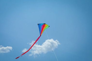 Mavi gökyüzünde uçan renkli uçurtma, alçak açı