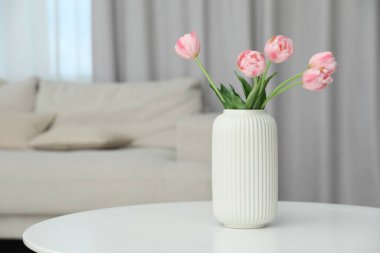 Beyaz masadaki vazodaki güzel lale çiçekleri, metin için yer.