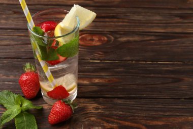 Çilekli içecek, ahşap masada limon ve nane şekeri, yakın plan. Metin için boşluk