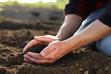 Arazide toprak yığını alan adam, yakın plan.