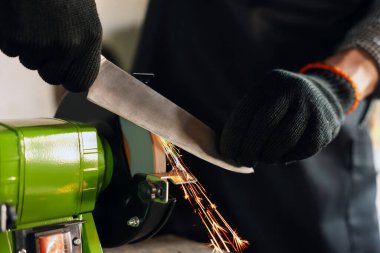 Bıçak keskinleştiren adam içeride, yakın plan.