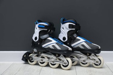 Siyah duvarın yanında bir çift paten var.