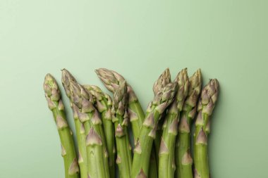 Yeşil arka planda taze taze çiğ kuşkonmaz, yakın plan. Metin için boşluk