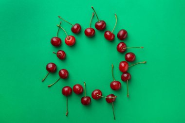 Yeşil arka planda taze olgun kiraz çerçevesi, düz. Metin için boşluk