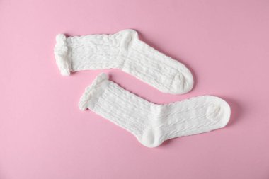 Pembe arka planda bir çift rahat beyaz çorap, üst manzara